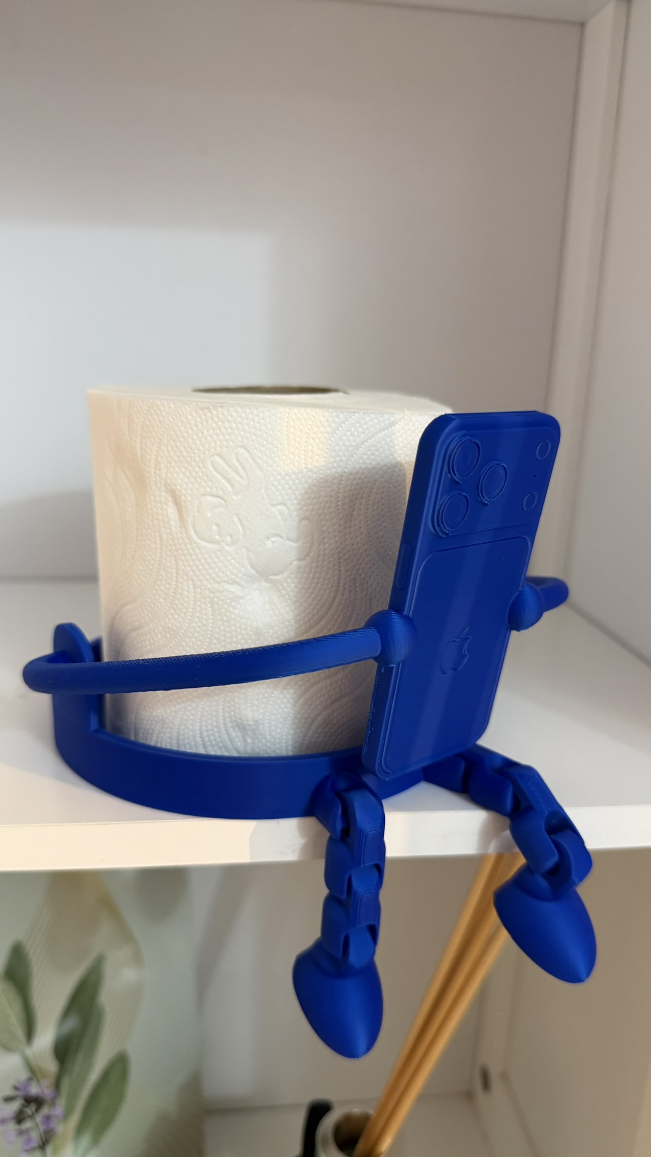 Porta rotolo blu con supporto smartphone visto lateralmente