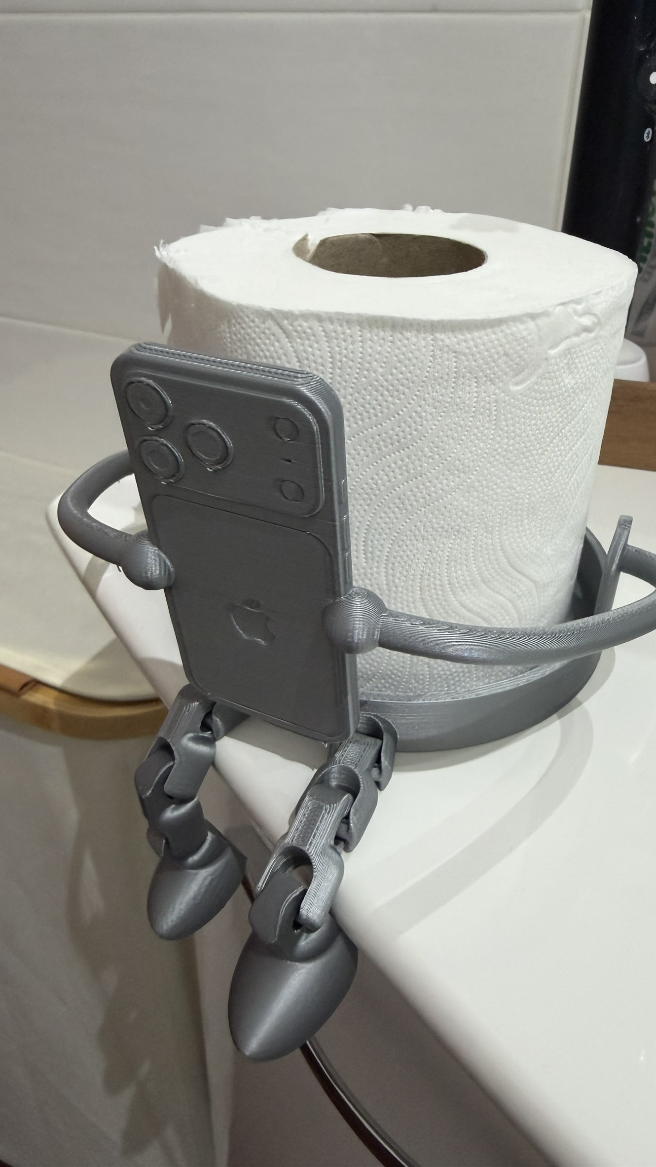 Porta rotolo grigio con supporto smartphone e gambe articolate