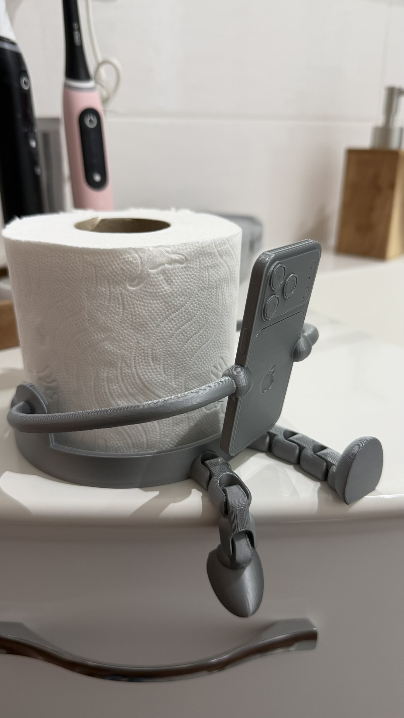 Porta rotolo grigio con supporto smartphone visto lateralmente